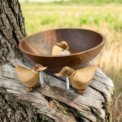 Bamboo wood duck figures with name tags by wooden bowl in nature scene