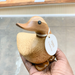 Hand holding bamboo wood duck with a name tag saying, "My name is Colin."