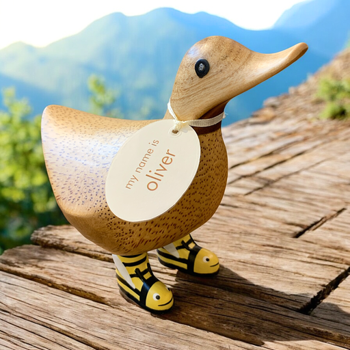 Adorable wooden duck figurine in bumblebee boots with name tag.