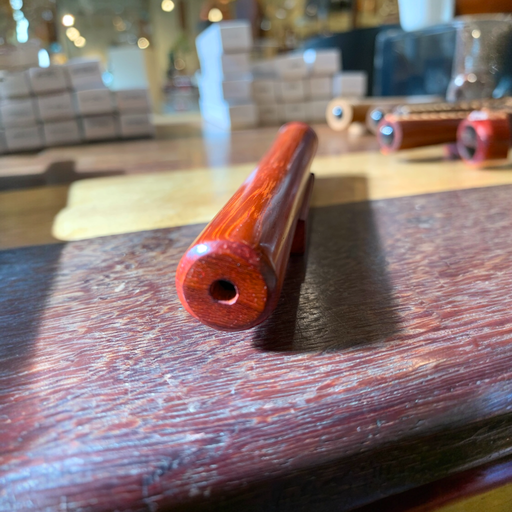 Wooden teleidoscope in African padauk with matching stand, vibrant natural finish.