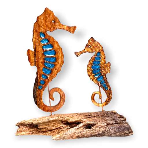 Check out these handcrafted feather and son seahorses displayed on a rustic wooden base. The body of each seahorse is embellished  with deep blue epoxy accents.